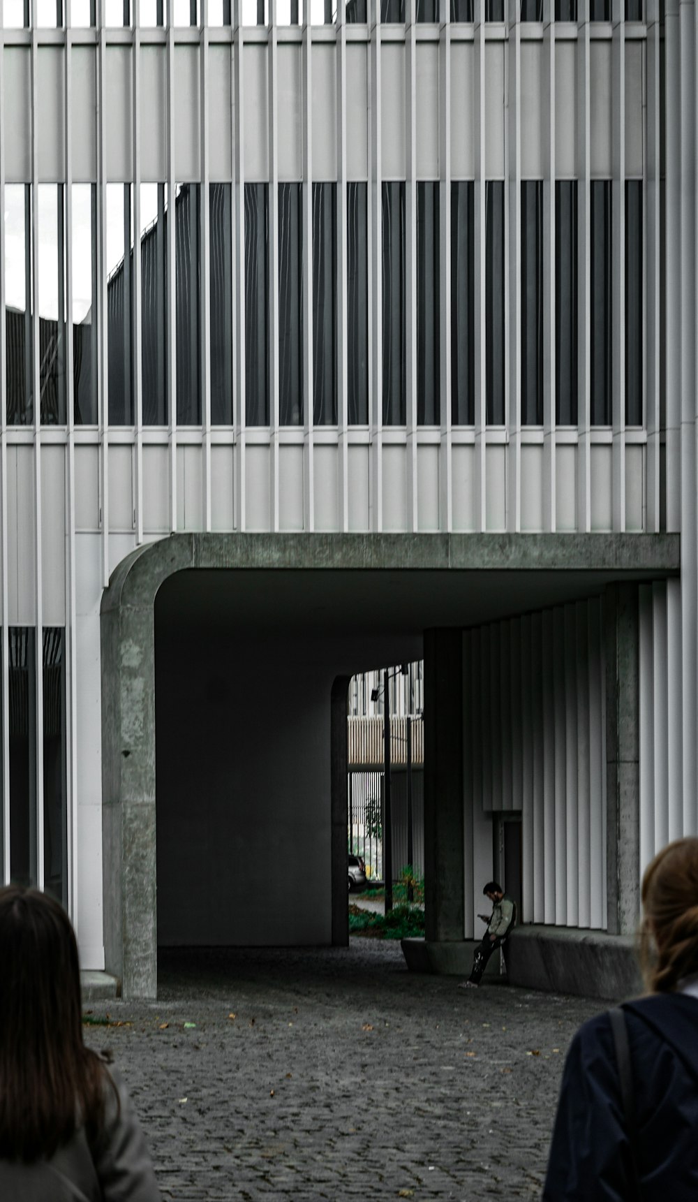 woman in black jacket standing near white concrete building during daytime