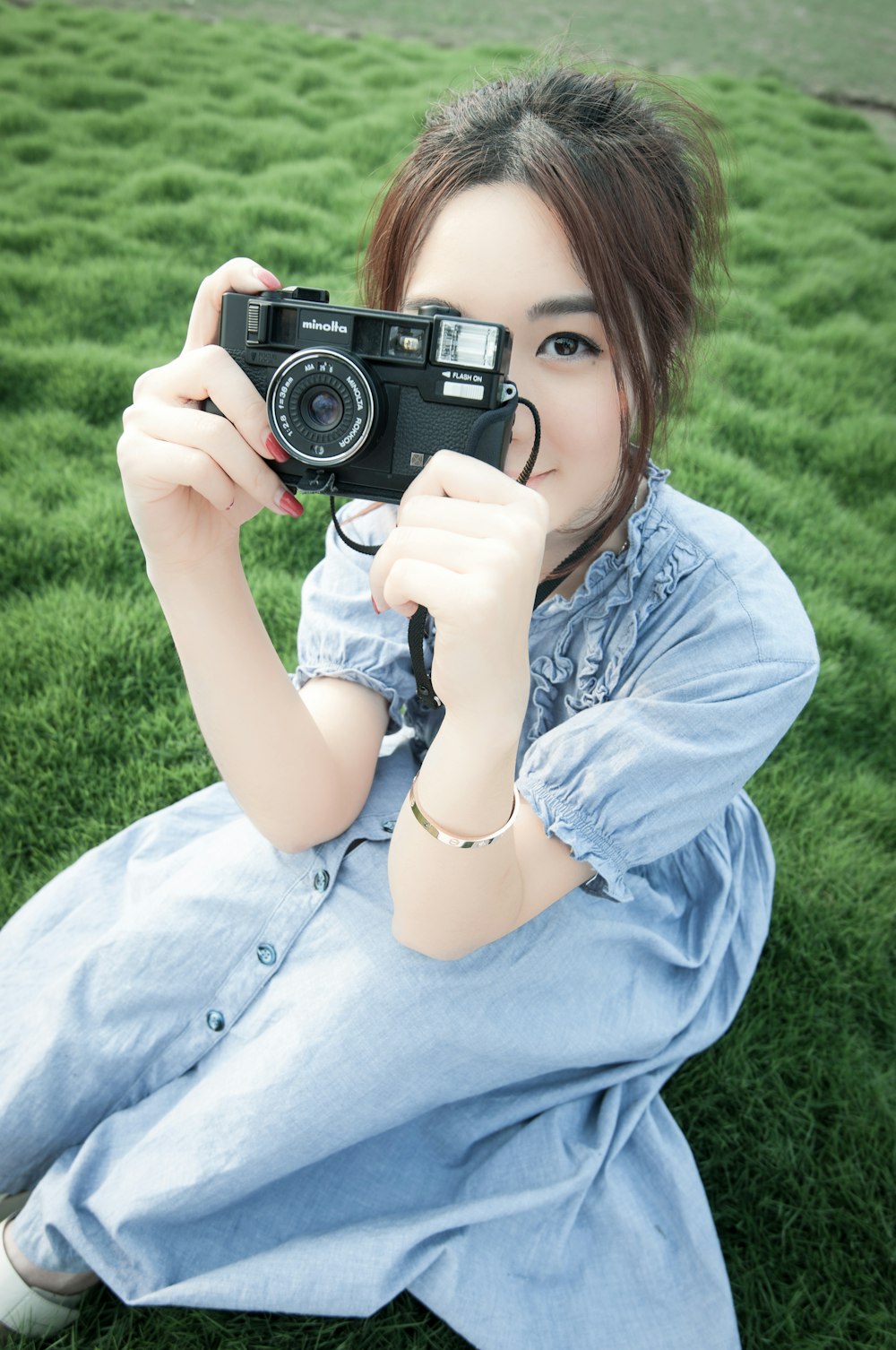 girl in blue dress holding camera