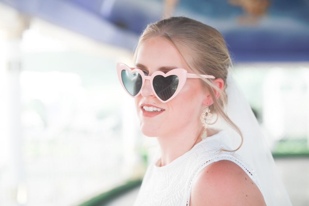 woman in white tank top wearing white framed sunglasses