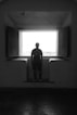 man in black shirt standing in front of window