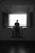 man in black shirt standing in front of window