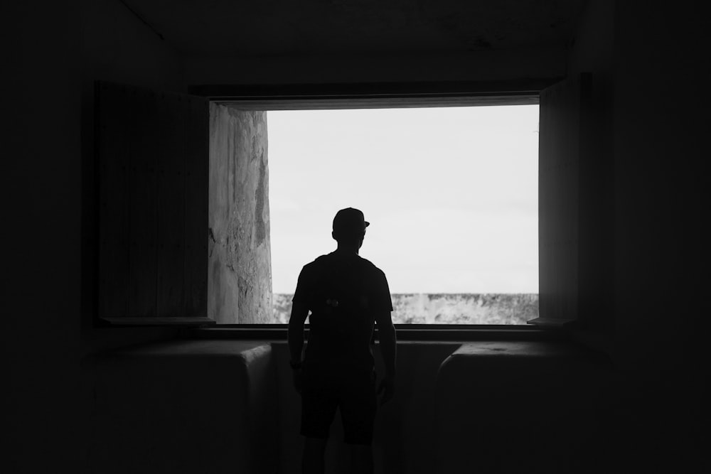 silhouette of man standing near window