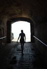 silhouette of person walking on tunnel