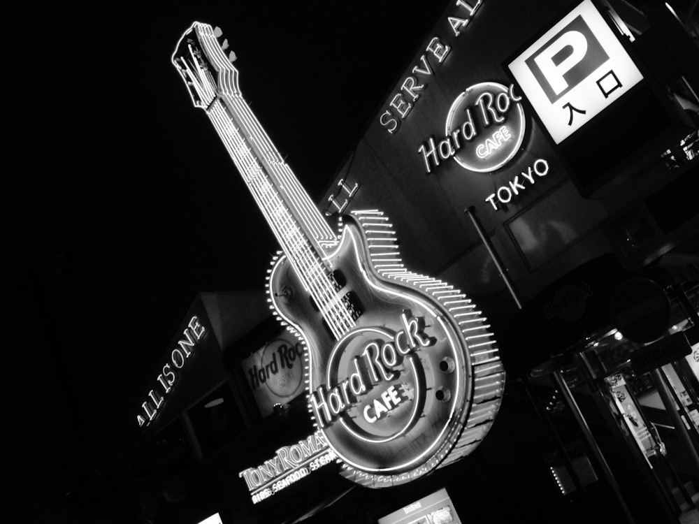 a black and white photo of a guitar sign