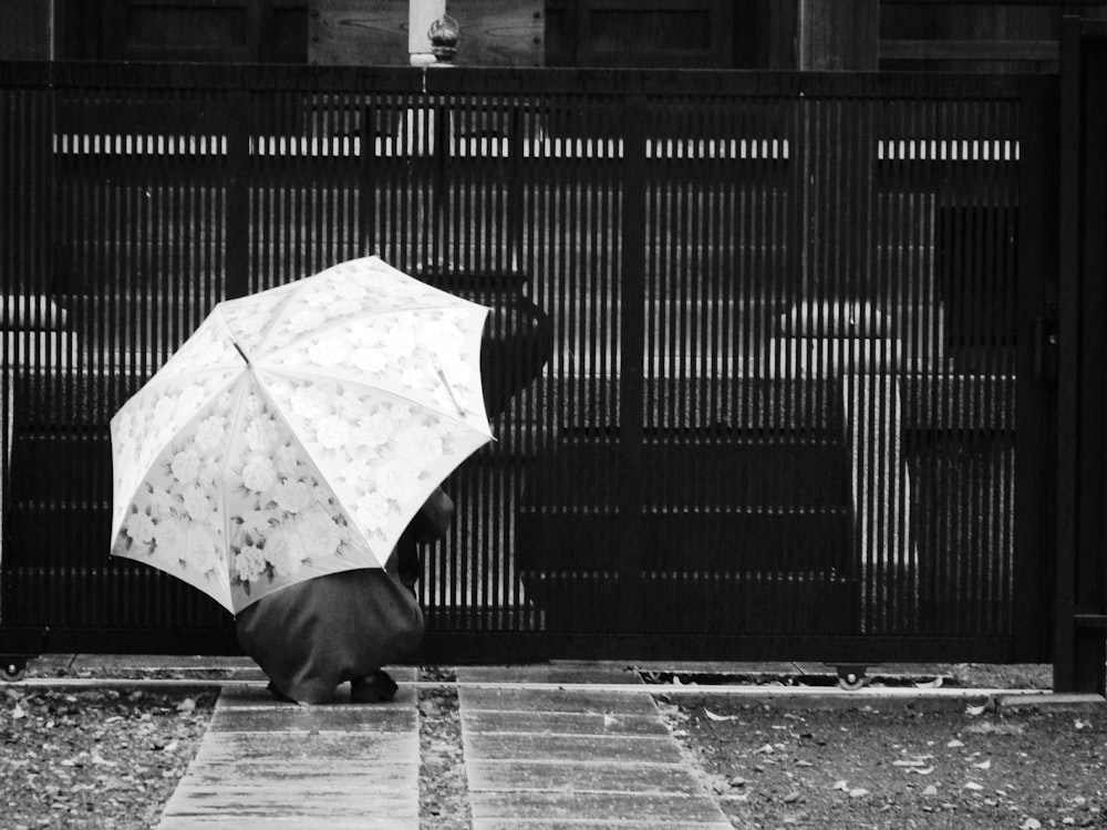 grayscale photo of umbrella on brick floor