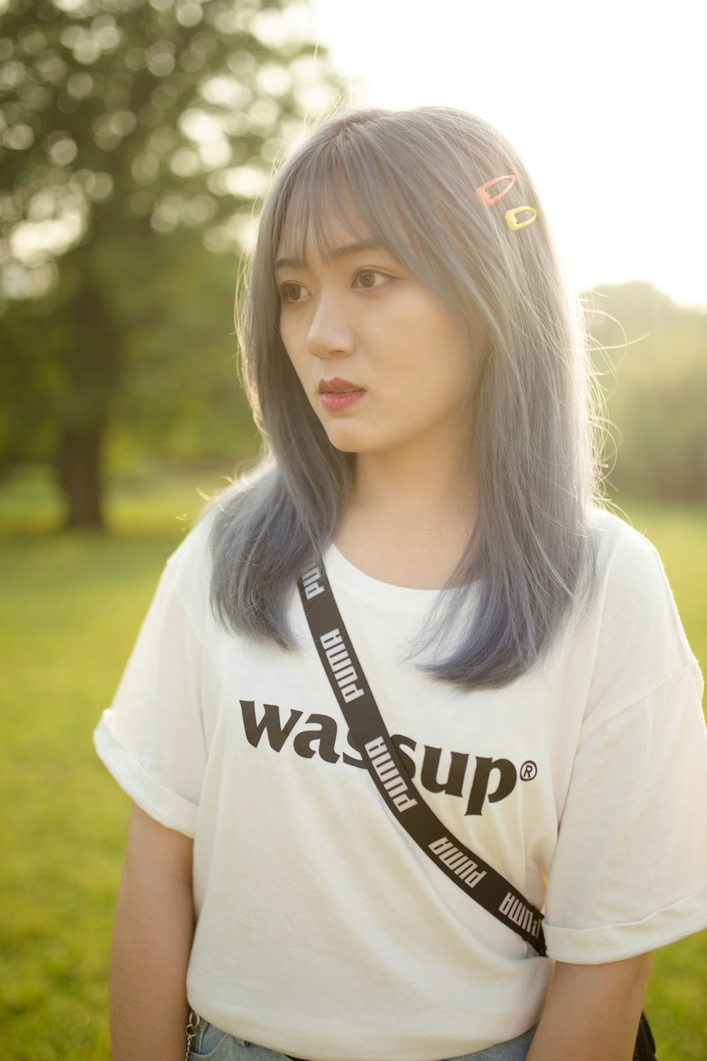 woman in white crew neck t-shirt standing on green grass field during daytime