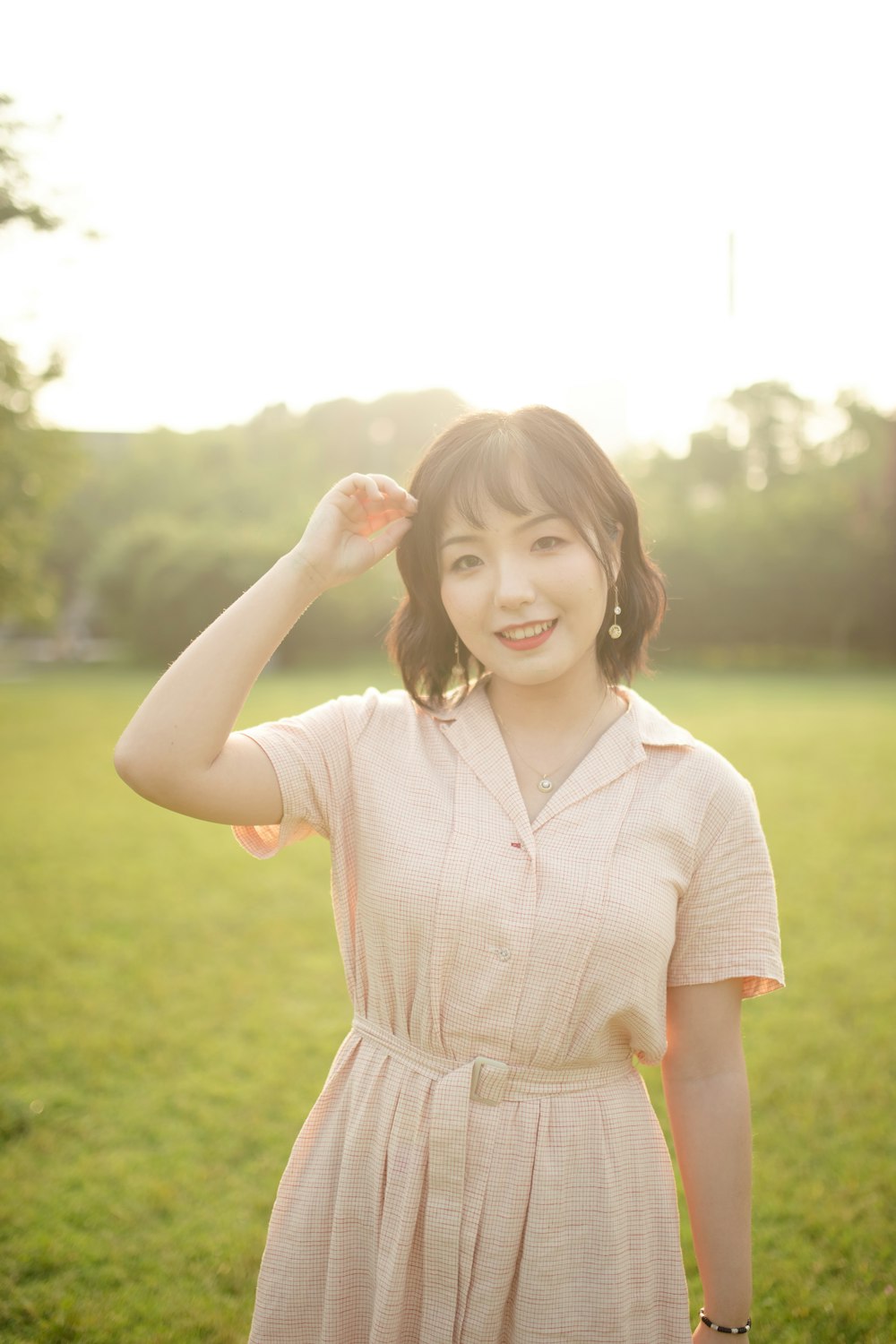 girl in white and brown dress standing on green grass field during daytime