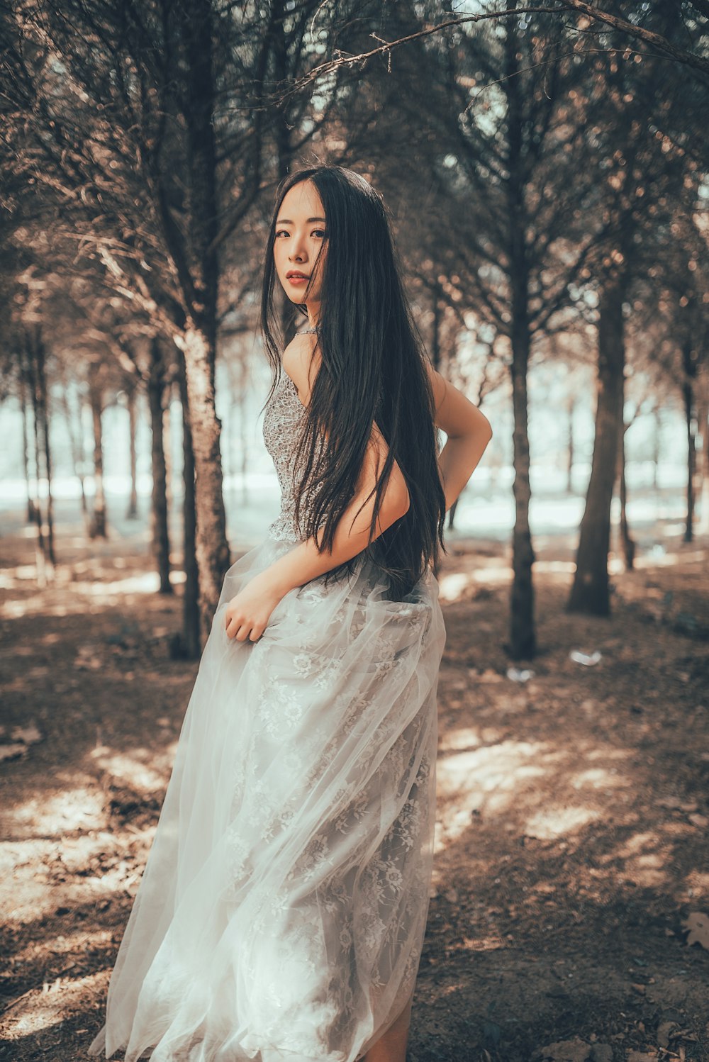 woman in white dress standing on brown soil during daytime