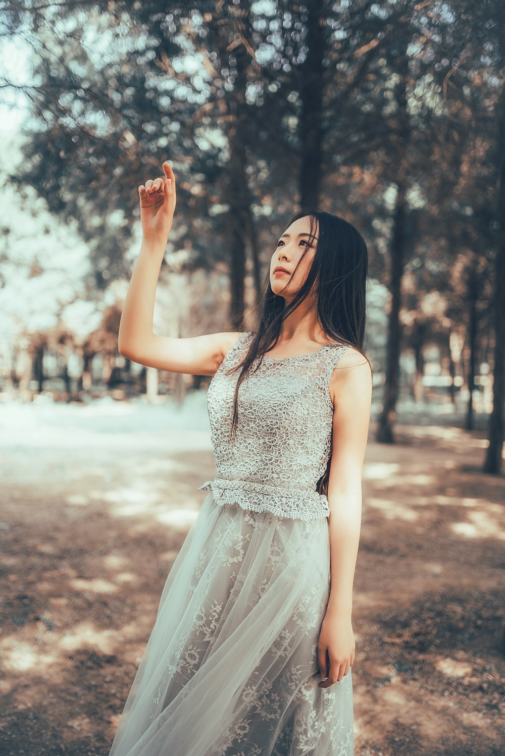 woman in white dress standing on brown field during daytime