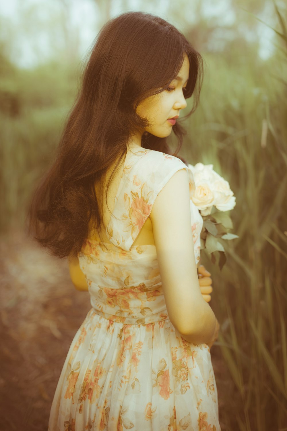 woman in yellow floral dress wearing black sunglasses