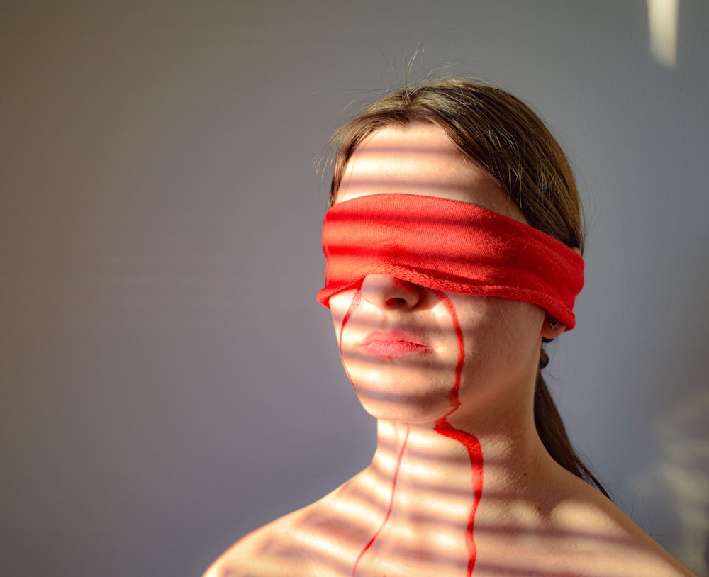 woman in white tank top with red and white striped knit cap