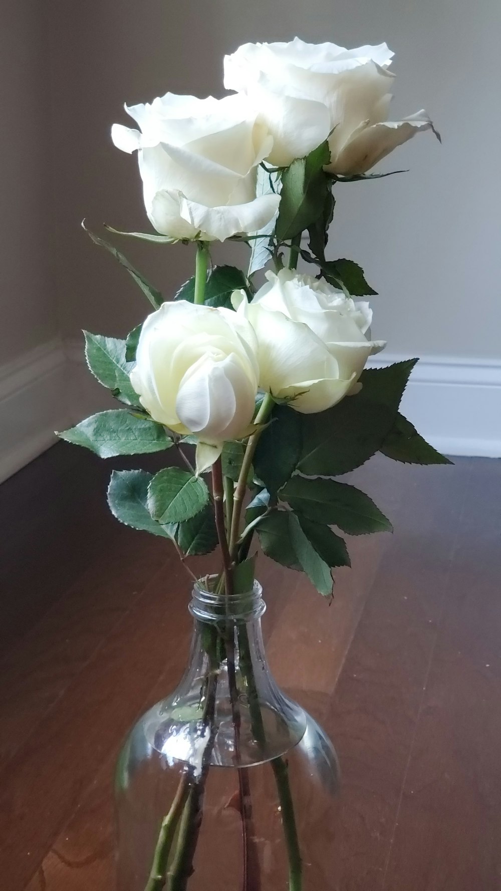 white roses in clear glass vase