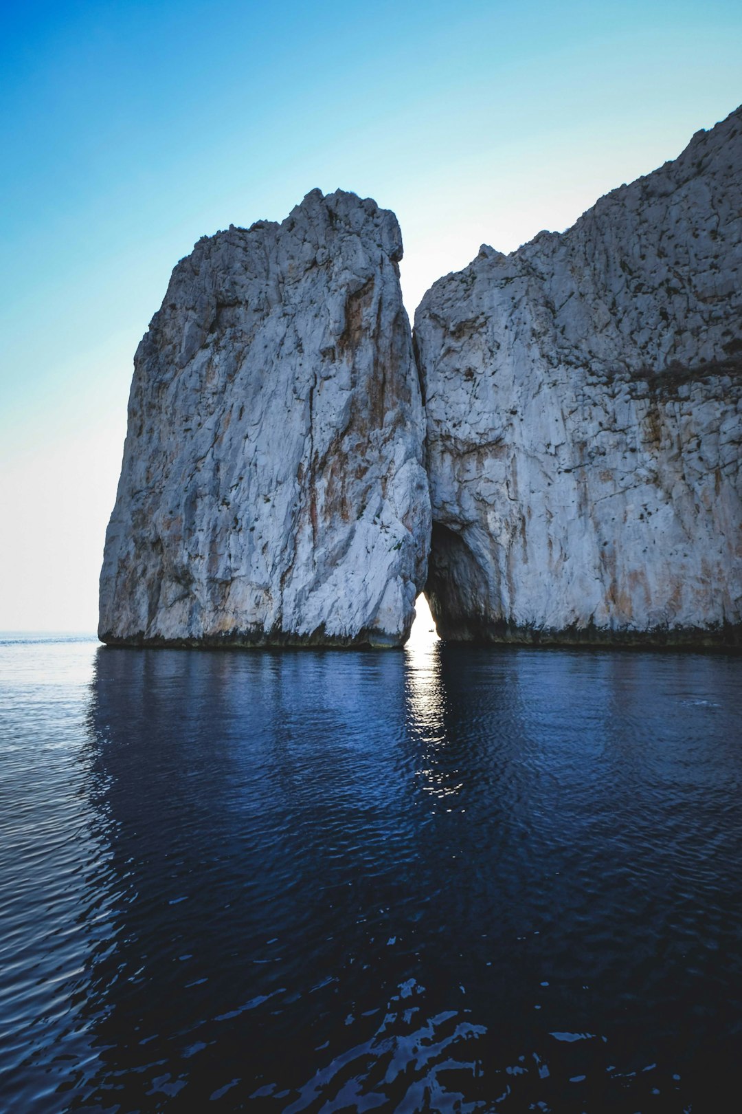 gray rock formation on blue sea under blue sky during daytime