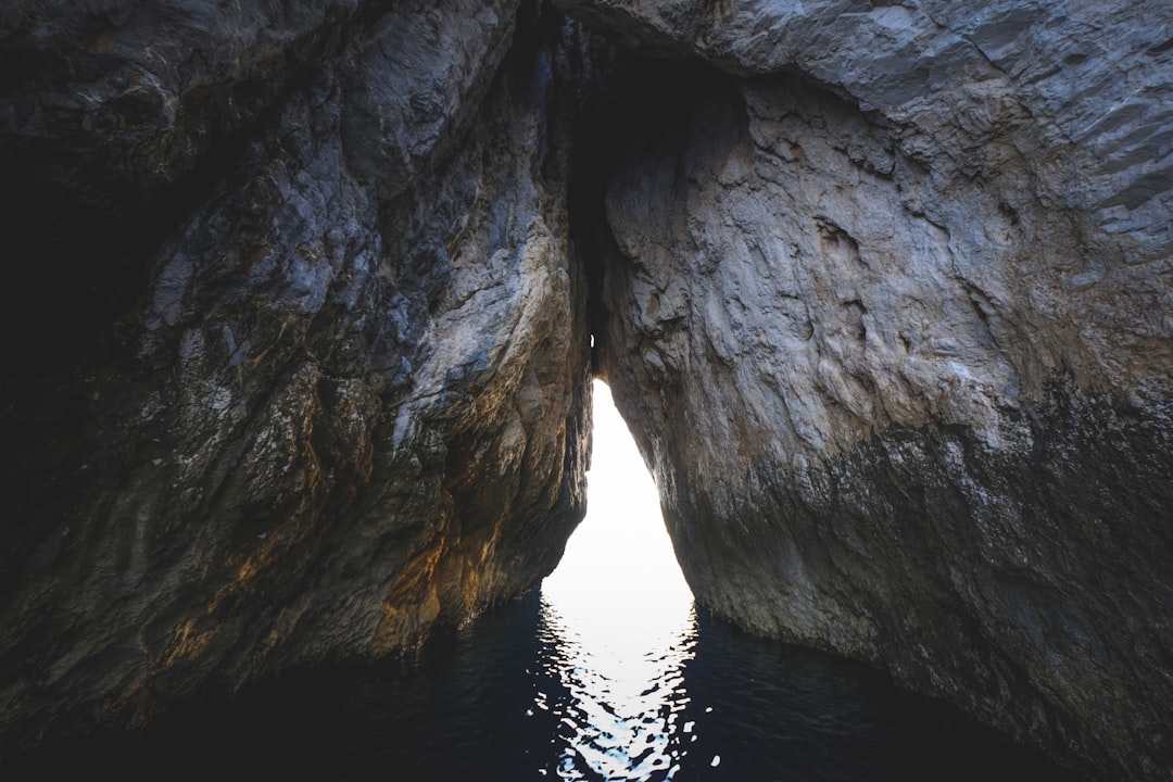 gray rock formation on body of water during daytime