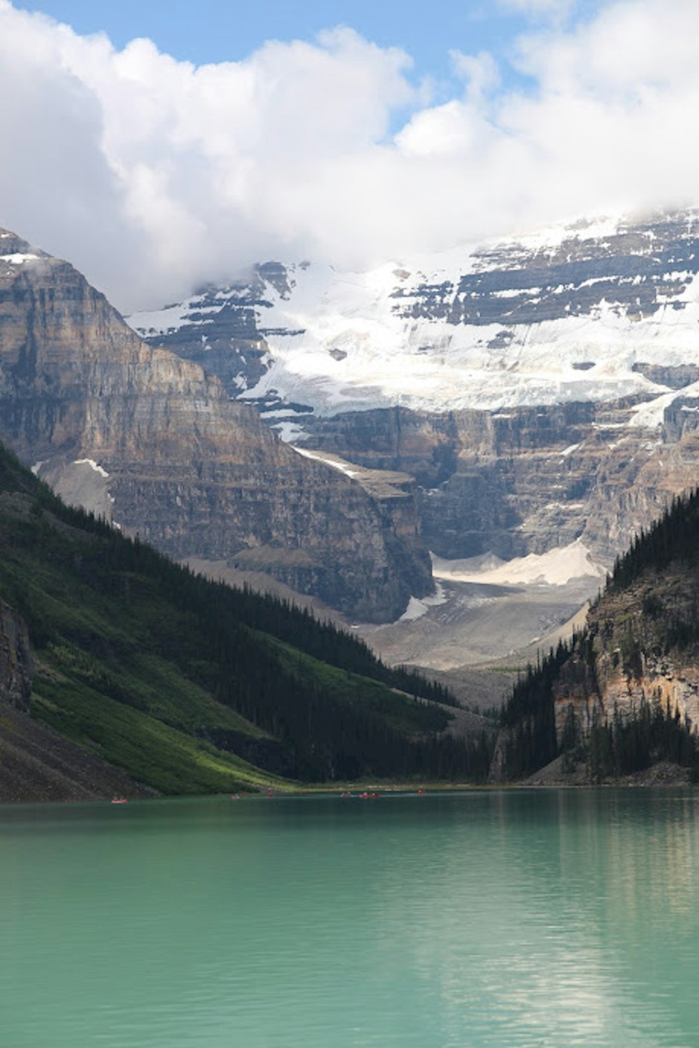 green lake near snow covered mountain during daytime