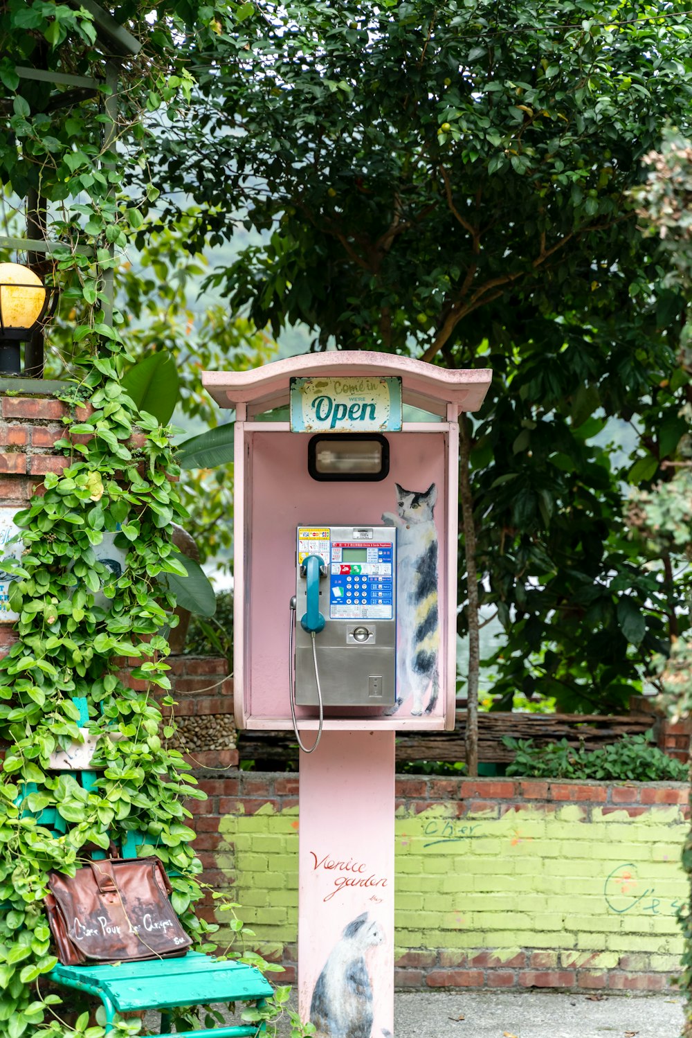 brown telephone booth near green plants during daytime