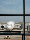 Front view of a modern passenger airplane from smpat enterprises parked at the airport gate.