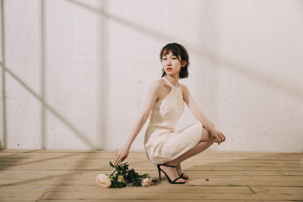 woman in white sleeveless dress holding bouquet of flowers