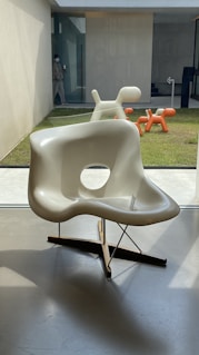 white plastic armchair on gray concrete floor