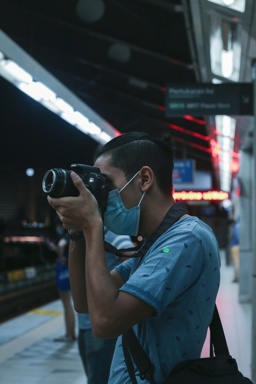 woman in blue shirt holding black dslr camera