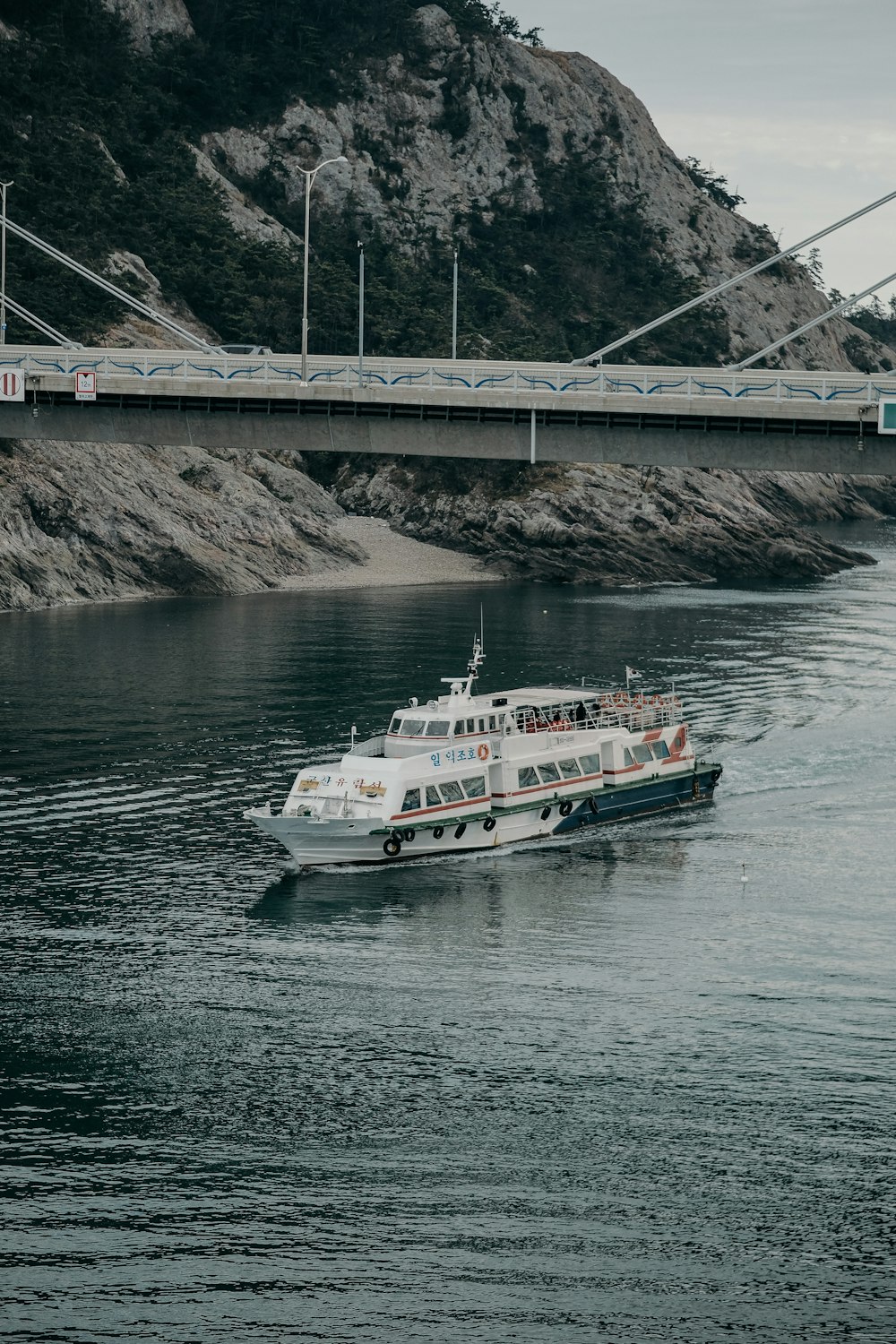 낮 동안 물 위에 흰색과 주황색 보트