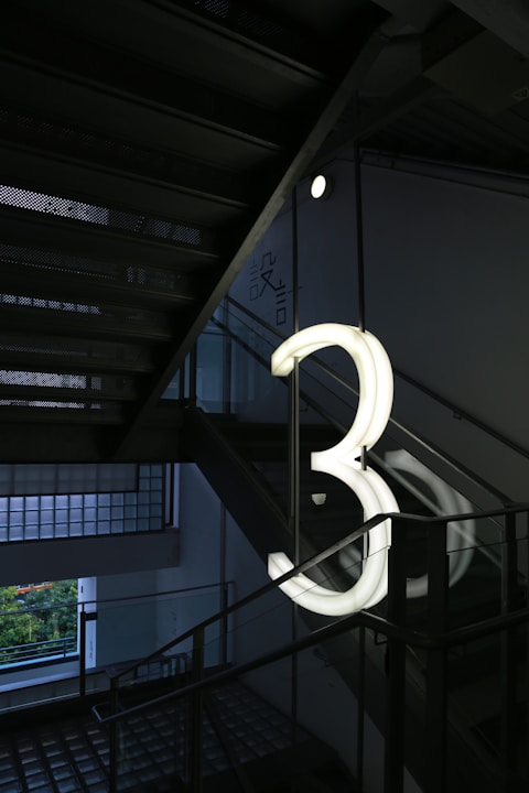 white spiral staircase near green trees during daytime