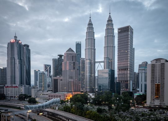 city buildings under white cloudy sky during daytime in Petronas Twin Towers Malaysia