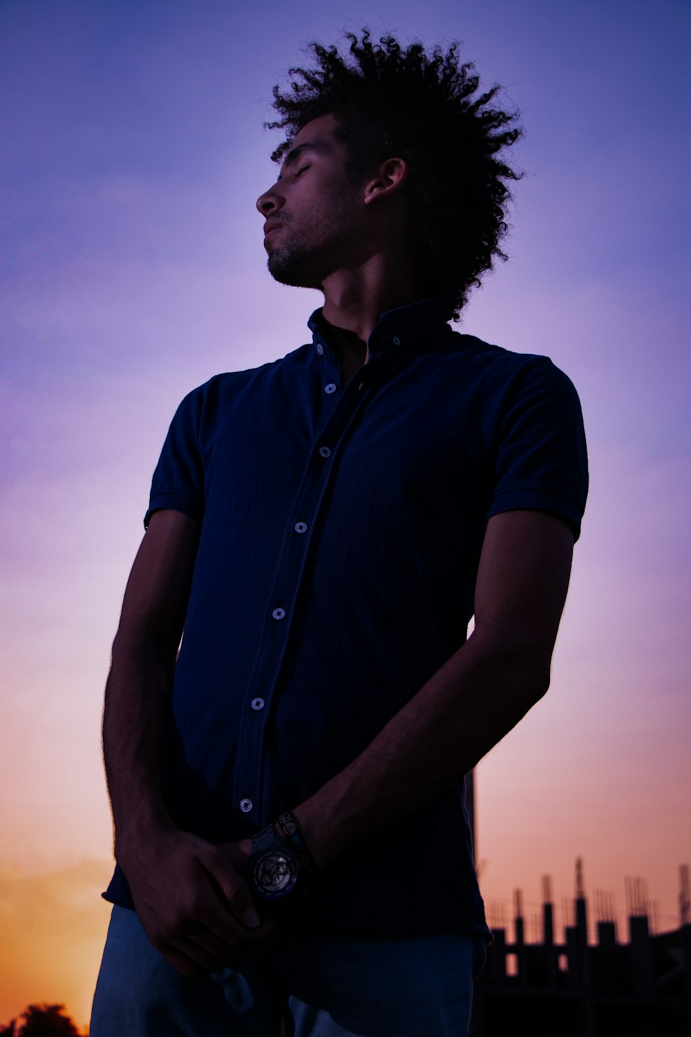 man in black button up shirt standing during sunset