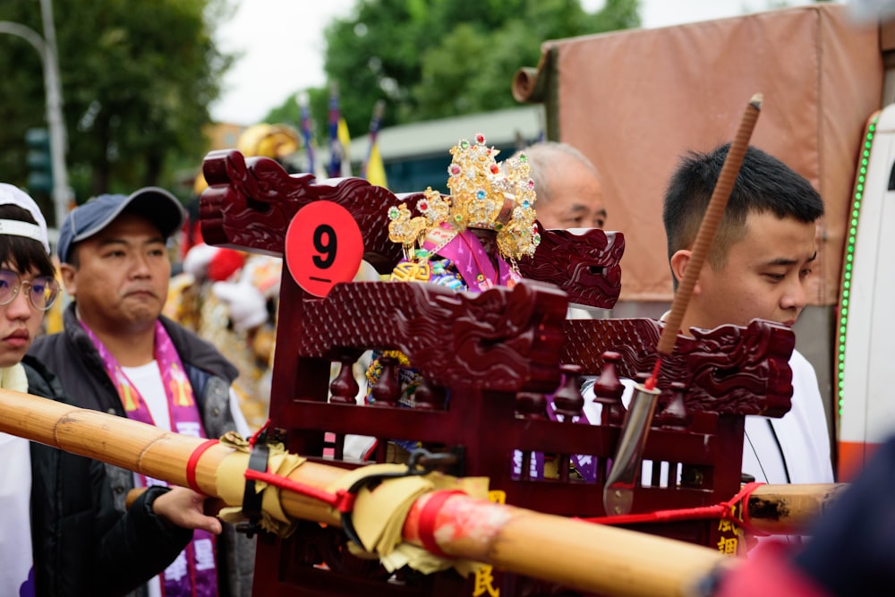 people in red and white dress holding brown wooden sticks during daytime