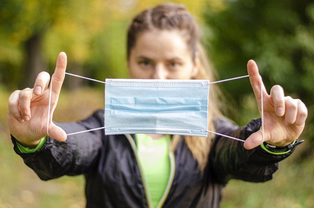 Junge in schwarzer Lederjacke mit blauem und weißem Papier