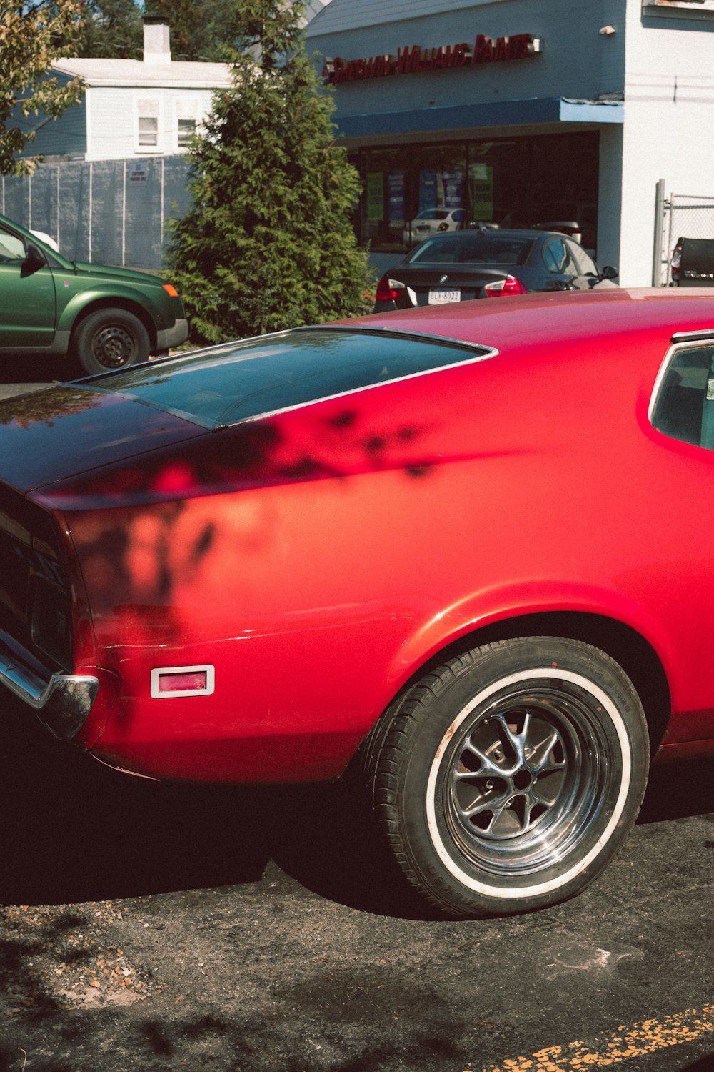 red car parked near green tree during daytime