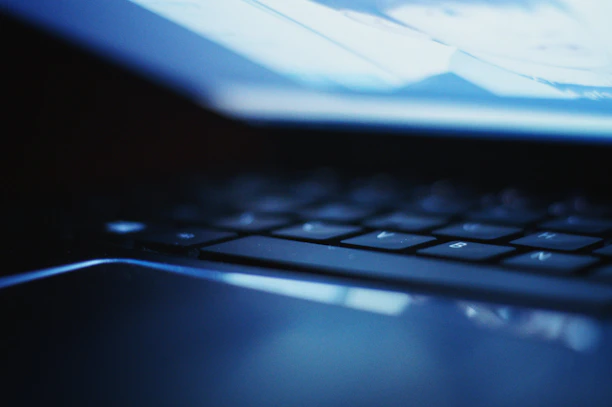 Close-up of a premium laptop keyboard illuminated by soft ambient light.