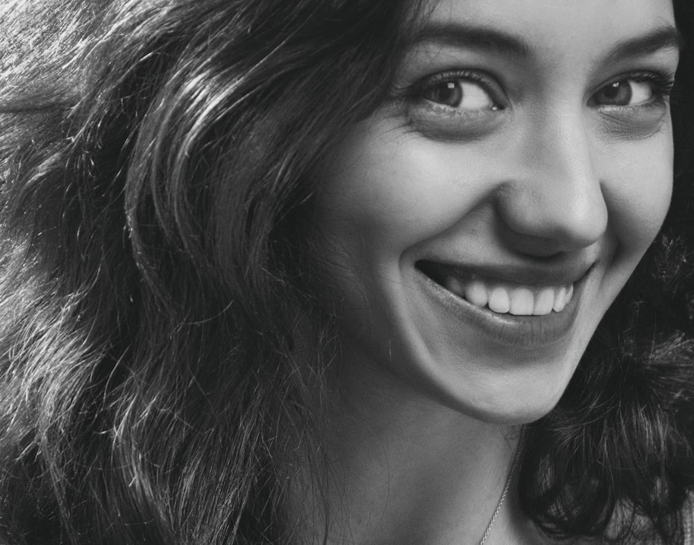 smiling woman in grayscale photo