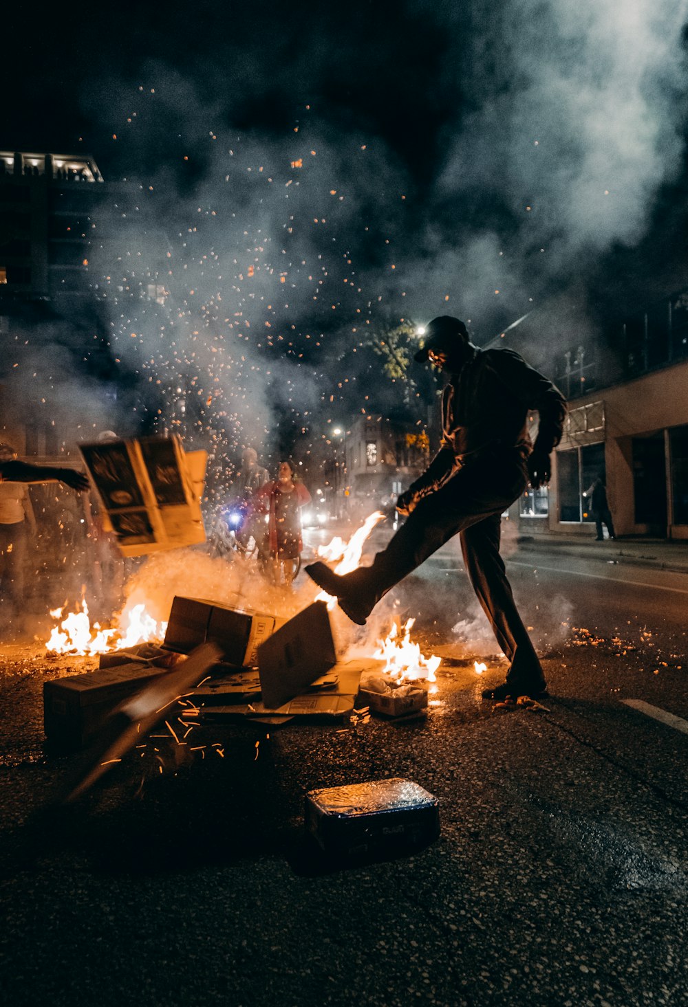 Hombre con camiseta negra y pantalones negros sosteniendo fuego