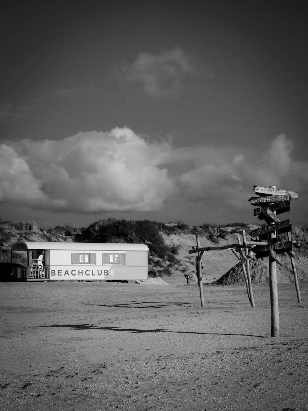 a black and white photo of a sign post and a building