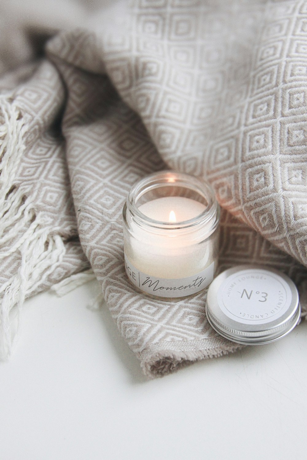 white candle on white textile
