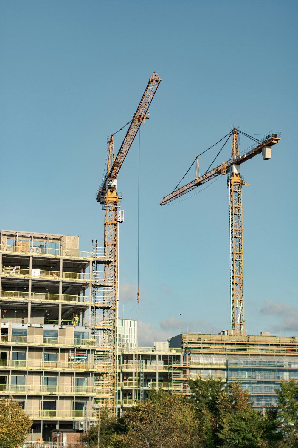 Gelber Kran in der Nähe eines weißen Betongebäudes tagsüber