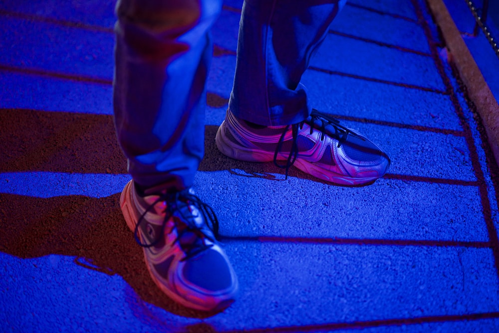 person in blue pants wearing black and white nike sneakers