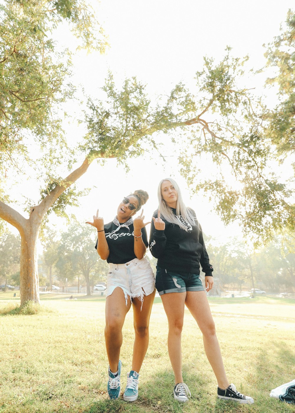 2 women standing under tree during daytime