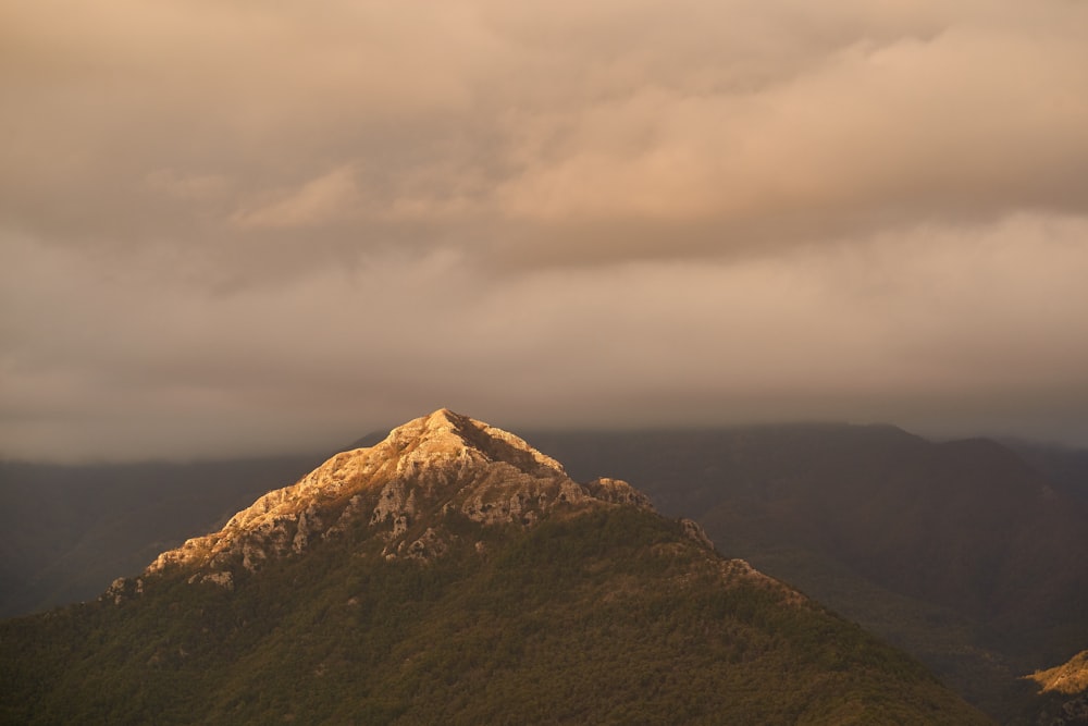 brown and green mountain under white clouds during daytime