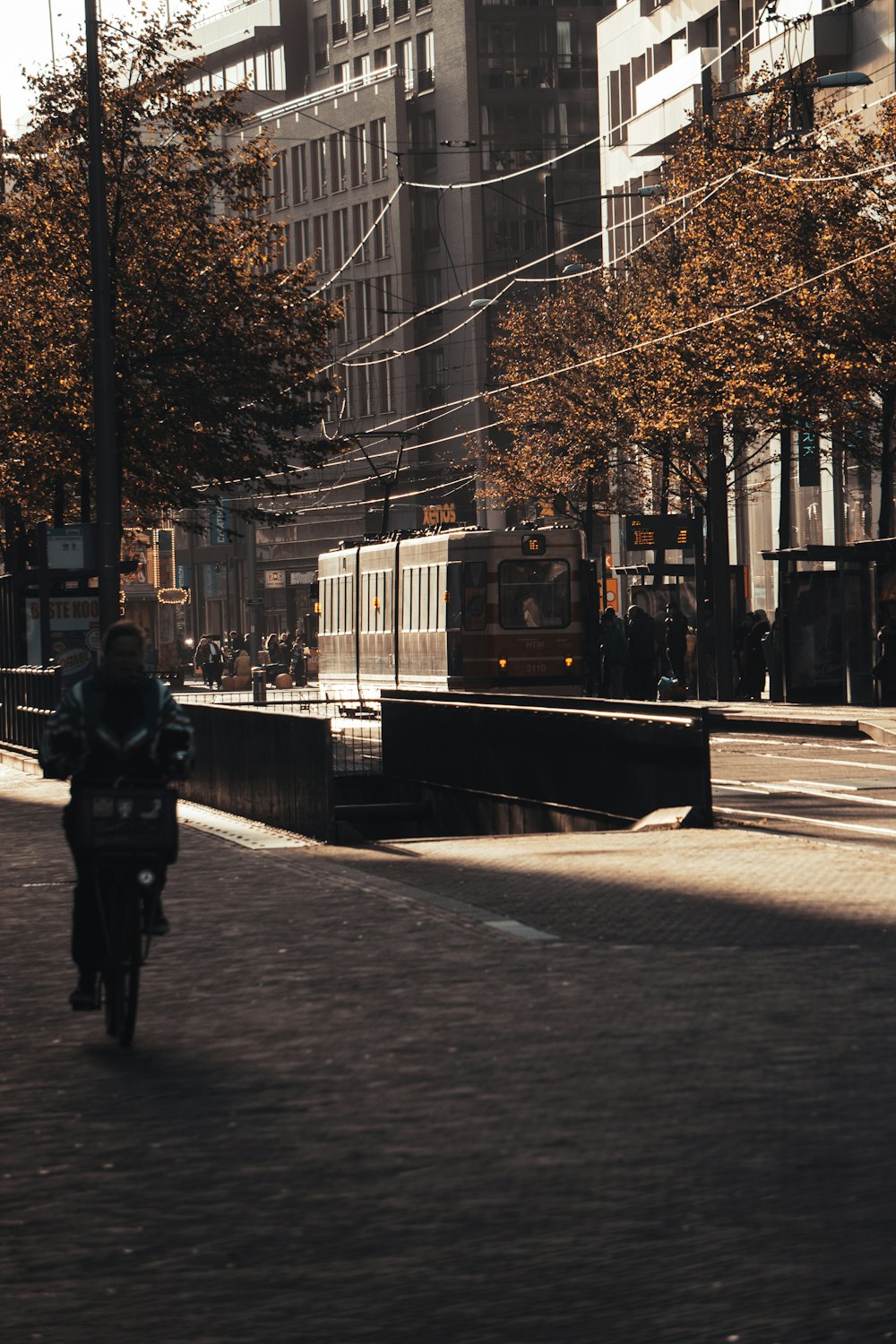 person in black jacket walking on sidewalk during daytime