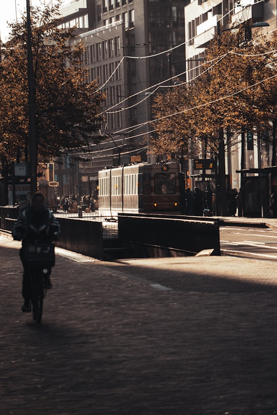 person in black jacket walking on sidewalk during daytime in Den Haag Netherlands