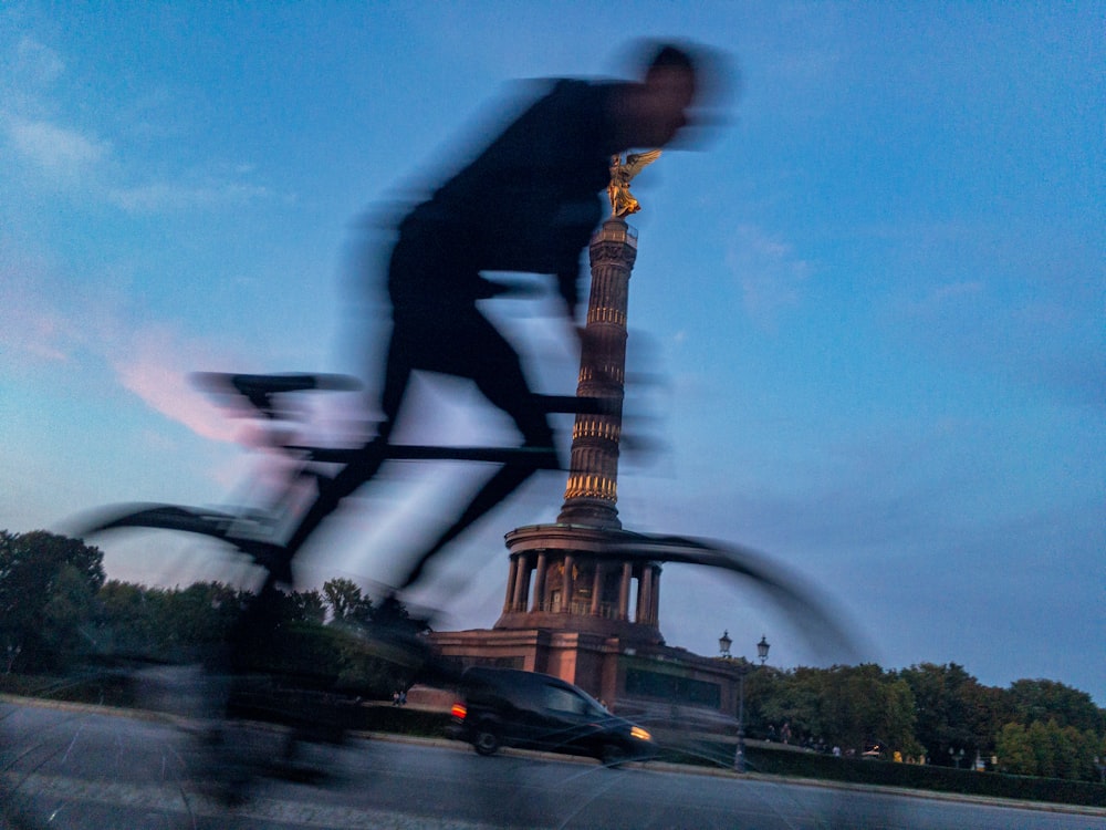 Mann in schwarzer Jacke und schwarzer Hose spielt tagsüber E-Gitarre in der Nähe des Eiffelturms