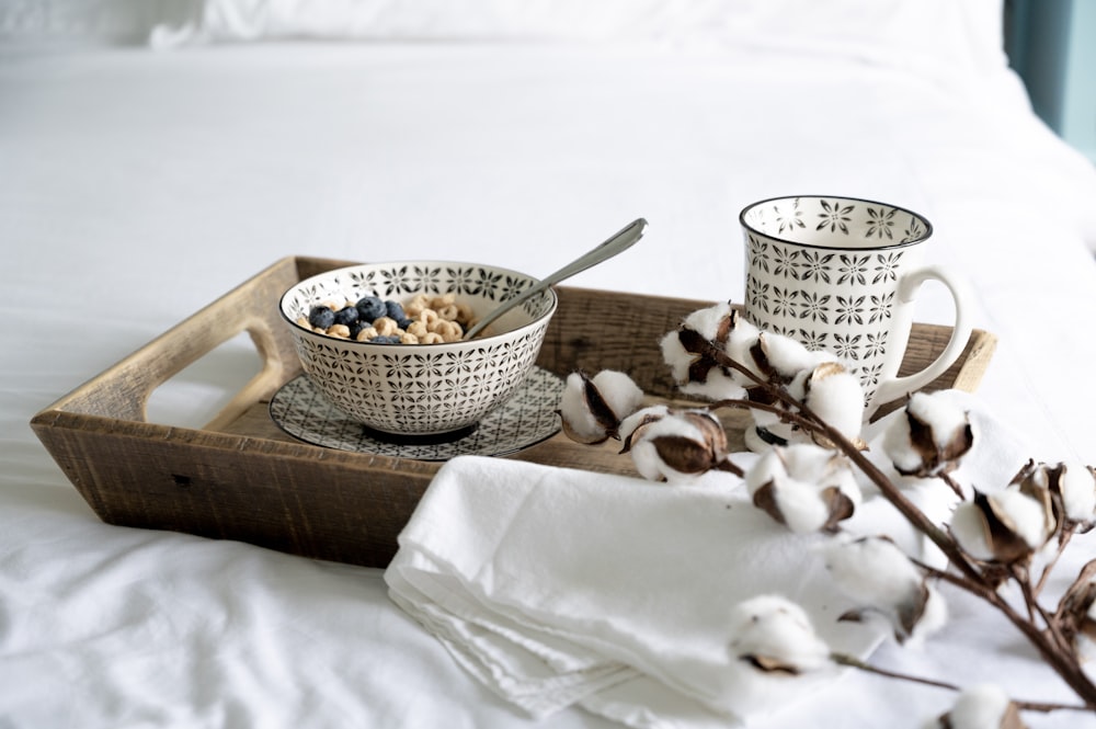 white and brown ceramic bowl on white textile