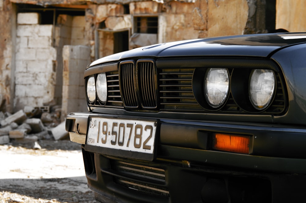 茶色のレンガ造りの建物の前に黒いBMWの車