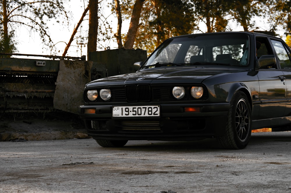 black bmw car parked near trees during daytime