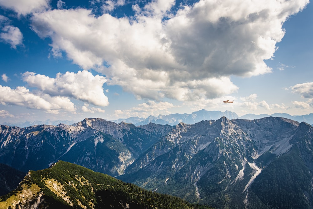 green and white mountains under white clouds and blue sky during daytime