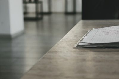 A stack of invoices and a pen on a wooden table.