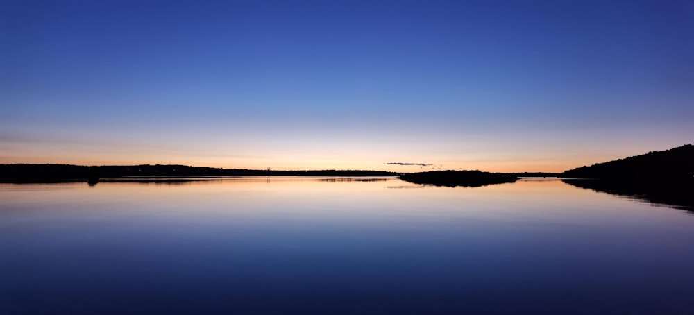 calm water under blue sky during daytime