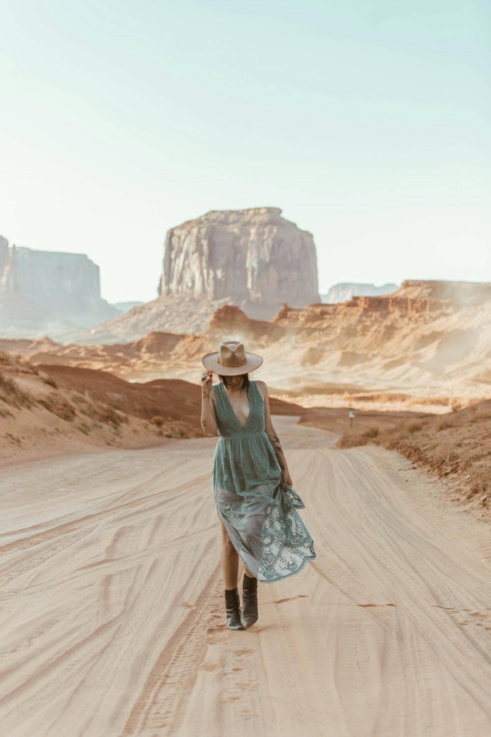 woman in green dress standing on brown sand during daytime